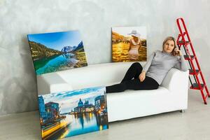 Girl hanging a frame canvas on a gray wall photo