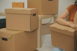 Beautiful young couple in love having fun unpacking things from cardboard boxes while moving in together in their new apartment photo