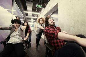 multiethnics business team racing on office chairs photo