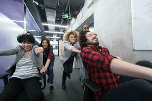 multiethnics business team racing on office chairs photo