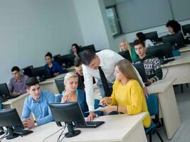 students with teacher  in computer lab classrom photo