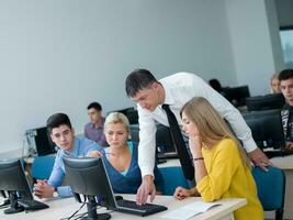 students with teacher  in computer lab classrom photo