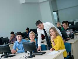 students with teacher  in computer lab classrom photo