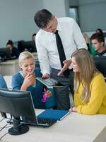 students with teacher  in computer lab classrom photo