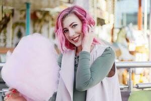 pink hair girl short haircut posing in amusement park on carousel background. photo