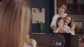 Daughter and mom sniff perfume. Three generations of women of a happy family. A grandmother, a young girl and a little girl - granddaughter spend time hugging, smiling, laughing in front of the mirror video