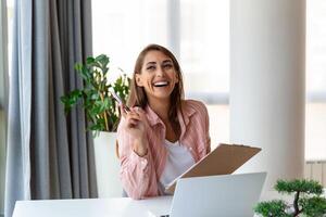 Focused business woman using laptop at home, looking at screen, chatting, reading or writing email, sitting on couch, female student doing homework, working on research project online photo