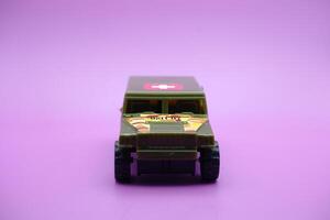 toy car isolated on purple background. imitation of an ambulance usually used by the armed forces. photo