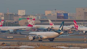 BANGKOK, THAILAND - JANUARY 19, 2023. Airplane of Cathay Pacific landing and braking to the runway at Suvarnabhumi Airport, Bangkok. Plane arriving. Spoilers up. Row of planes parked video