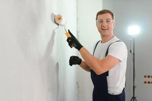 One painter with paint roller making wall prime coating at home repair renovation work. photo