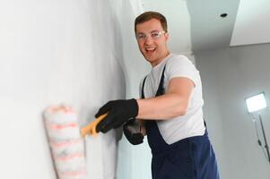 One painter with paint roller making wall prime coating at home repair renovation work. photo