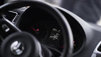 Close up of steering wheel dashboard with a moving engine speed scale arrow. Action. Interior of a passenger car. video