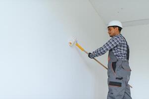 Indian worker makes repairs in an apartment photo