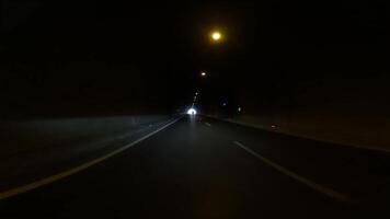 Car exits illuminated tunnel. captures transition from illuminated tunnel, highlighting journey. Focus on illuminated tunnel exit, showing contrast with darkness inside video