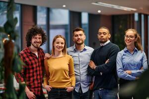 Portrait of successful creative business team looking at camera and smiling. Diverse business people standing together at startup. Selective focus photo