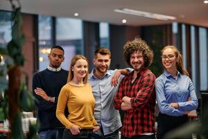 Portrait of successful creative business team looking at camera and smiling. Diverse business people standing together at startup. Selective focus photo