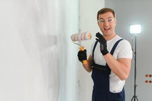 repair, building and home concept - close up of male in gloves holding painting roller photo