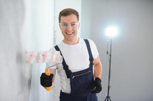 Worker painter paints a wall. Professional builder makes repairs. photo