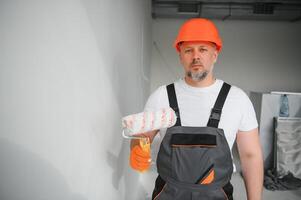 Man stand in the room with paint roller in his hand photo