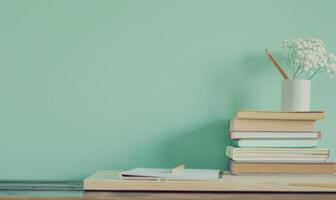 Stack of books on a wooden desk with a pastel mint green background photo