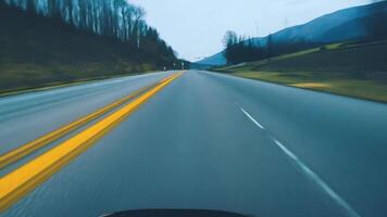 Front pov view of fast car driving on asphalt road with double yellow lines converge video