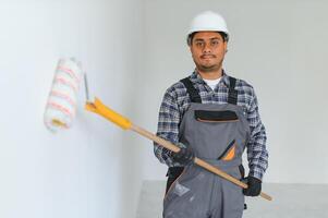 Indian worker makes repairs in an apartment photo