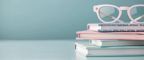 Glasses Resting on Stack of Teal Books With Mug in Soft Natural Light photo