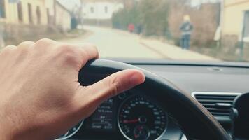 Male hand on the wheel of a car. The thumb reflects the musical rhythm on the steering wheel. Close up of a hand driving a car. video