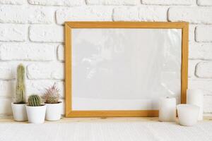 Square wooden photo frame and cactus plants on the table