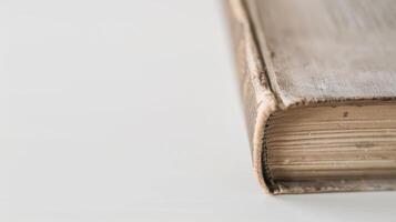 Old book with a worn spine resting on a white table, evoking history photo