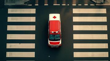 Emergency ambulance crossing a busy pedestrian crosswalk in an urban area during the day photo