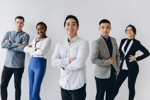 Cheerful multiracial professional business people laughing together standing in row near wall, happy diverse young employees students group, corporate staff team having fun, human resource concept photo