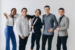 Cheerful multiracial professional business people laughing together standing in row near wall, happy diverse young employees students group, corporate staff team having fun, human resource concept photo