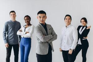 Cheerful multiracial professional business people laughing together standing in row near wall, happy diverse young employees students group, corporate staff team having fun, human resource concept photo