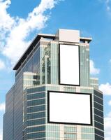 Mock up white vertical and horizontal LED display billboard on tower building with blue sky background .clipping path for mockup photo