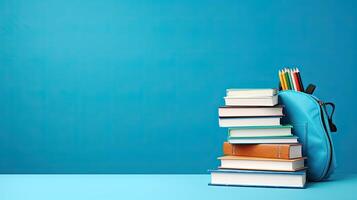 Backpack with books and pencils on blue background photo