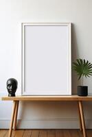 Blank white frame mockup on wooden table with plant and vase photo