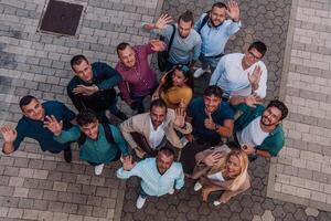 A top view photo of group of businessmen and colleagues standing together, looking towards the camera, symbolizing unity and teamwork.