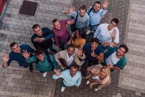 A top view photo of group of businessmen and colleagues standing together, looking towards the camera, symbolizing unity and teamwork.