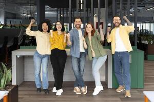 Group of excited business people celebrating success in office photo