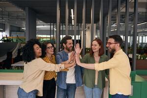 Happy business people giving high five celebrating success in office photo