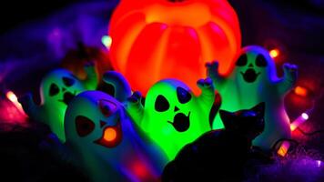 glowing plastic ghosts a black cat figurine create a spooky halloween scene photo