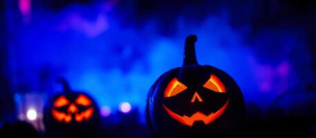 carved pumpkin with a grinning face stands out against a blue smoky background photo