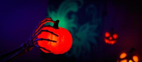 glowing skeletal hand holds a pumpkin photo