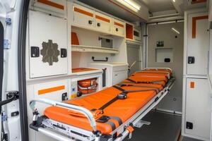 Empty stretcher waiting for patient inside ambulance with medical equipment photo