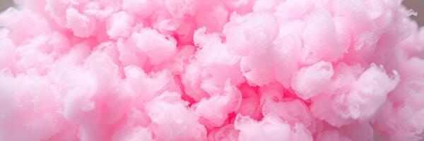 Fluffy pink cotton candy prepared at a carnival event during sunny day with cheerful atmosphere photo