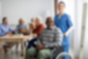 Happy black man older patient on wheelchair with female nurse smiling at camera, group of 