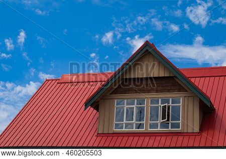 Red Roof With Dormer In The Blue Sky Background. Decorative Metal Roof. Types Of Roof Roofs.the Roof