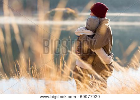 back view of lovely young couple hugging in winter