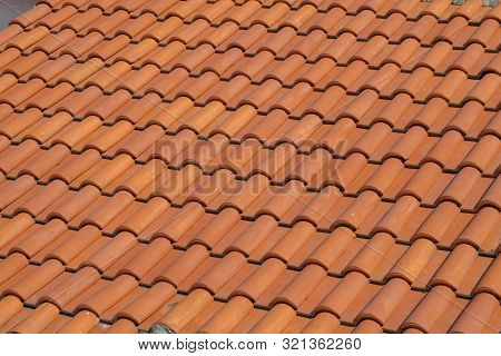 Roof top view. Red tile. The pattern of roof tile. Orange tile roof, abstract background. Roofing texture. Red corrugated tile element of roof. Seamless pattern.